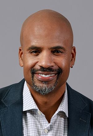 Masud Olufani, a bald, attractive African American man