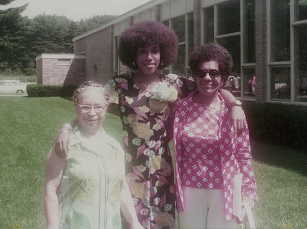 14-year-old African American girl in multicolored dress with her grandmothers beside her