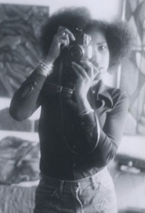 African American teenage girl photographing herself in a mirror