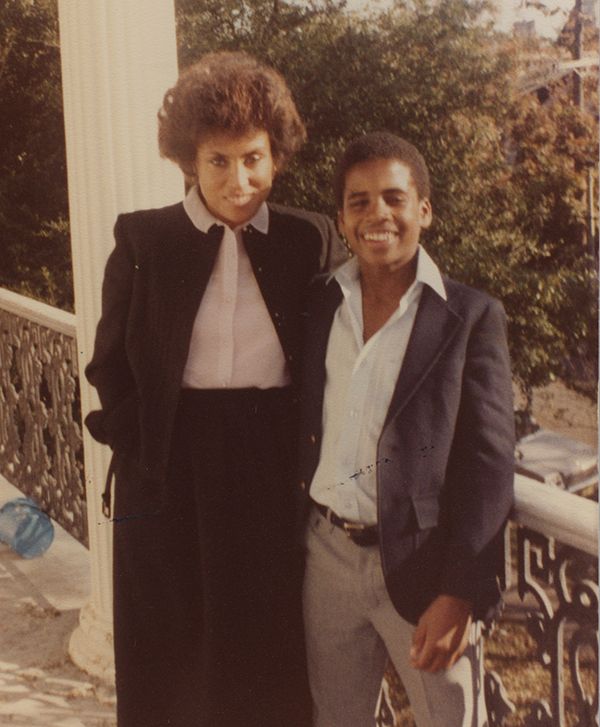 African American mother and her 14-year-old son standing on a balcony