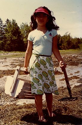 Eight-year-old girl with bucket and rake for digging clams in Maine
